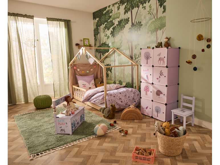 Chambre d'enfant avec lit cabane, étagères roses et tapis.