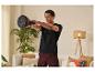 Un homme fait de l'exercice à la maison avec des kettlebells Reebok.