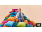 Petite fille souriante assise sur une pile de coussins colorés.