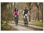 Deux personnes font du vélo de montagne dans une forêt.
