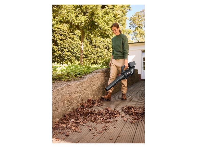 Femme utilisant le souffleur de feuilles sans fil PARKSIDE PERFORMANCE sur une terrasse en bois.