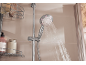 Pommeau de douche avec jet d'eau et étagère de douche avec bouteilles.