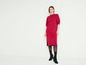 Une femme portant une robe en tricot rouge et des bottes noires.