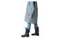 Enfant en imperméable bleu, jean et bottes de pluie noires.