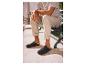 Homme en t-shirt rayé et pantalon beige assis sur un banc, portant des sabots noirs.