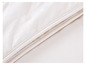 Gros plan sur une couette blanche avec une bordure cousue.