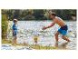 Père et fils jouent avec un ballon dans l'eau, portant des maillots de bain.
