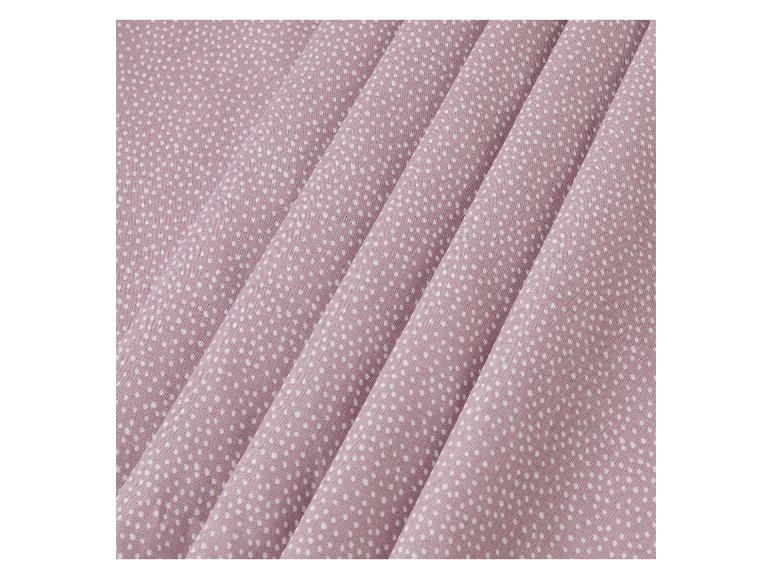 Tissu rose poudré à pois blancs.