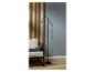 Un lampadaire noir à côté d'un fauteuil dans un intérieur moderne.