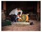 Homme réparant tondeuse avec lampe de travail LIVARNO® »The Portable« dans un abri sombre.