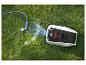 Tondeuse robot détectant un tuyau d'arrosage sur l'herbe verte.