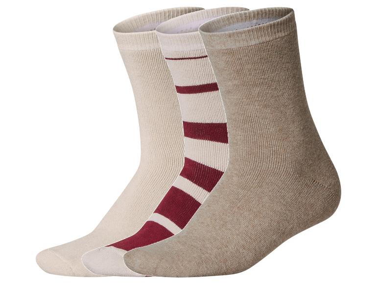 Trois chaussettes, une beige, une à rayures rouges et blanches, et une marron clair.