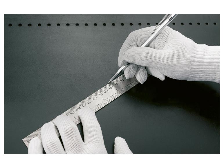 Une main portant un gant blanc tient une règle et un crayon