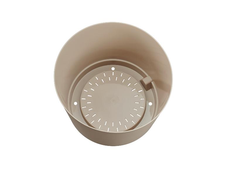 Pot de fleurs en plastique beige avec insert de drainage, vu de dessus.