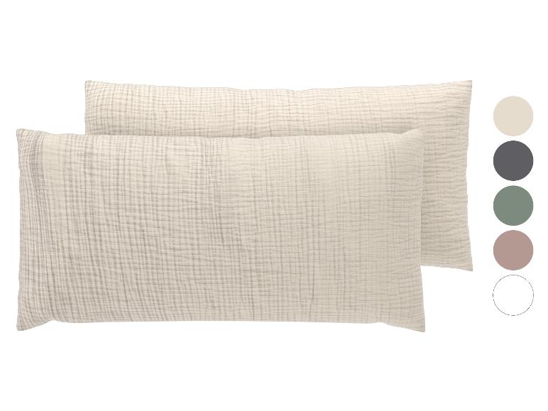 Deux taies d'oreiller rectangulaires en mousseline de coton beige clair avec des échantillons de couleur.
