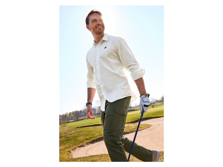 Homme jouant au golf avec une chemise blanche et un pantalon cargo.