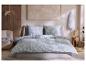 Chambre avec parure de lit florale bleue, boiseries et mobilier moderne.