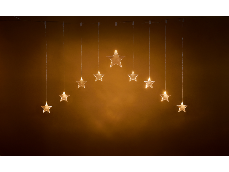 Guirlande lumineuse dorée en forme d'étoiles formant un arc sur fond sombre.