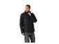 Homme en veste imperméable noire et jean gris, regardant sur le côté.