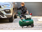 Compresseur d'air et personne changeant un pneu de voiture.