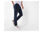 Un homme porte un pantalon cargo bleu marine US Polo Assn. et des baskets grises.