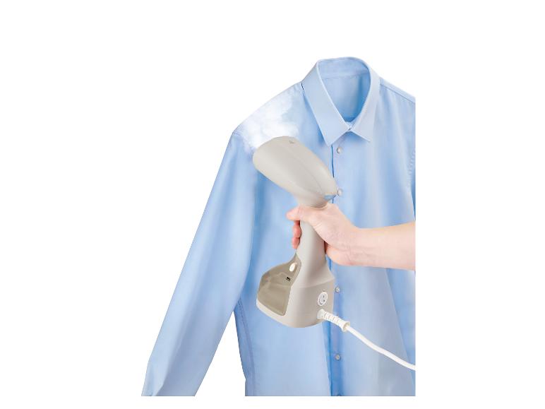 Un fer à repasser à vapeur utilisé pour repasser une chemise bleue.