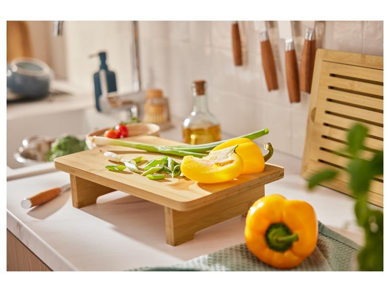 Planche à découper en bambou avec poivrons et oignons verts.