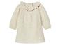 Robe bébé beige à manches longues et col volanté.