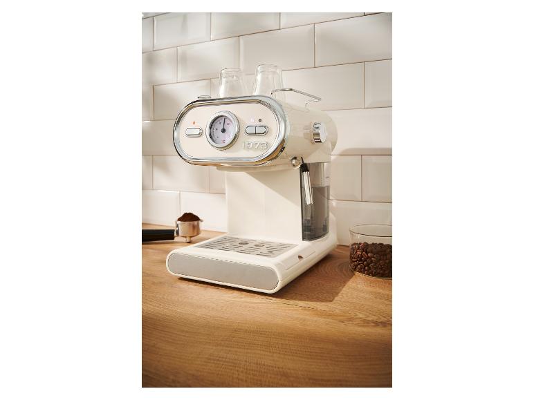 Machine à expresso crème avec manomètre et accessoires sur un comptoir en bois.