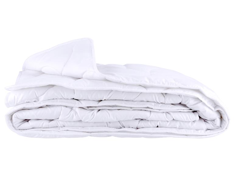 Une couette blanche pliée, isolée sur un fond blanc.