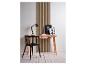 Une chaise noire et un bureau en bois avec une lampe et des cadres photo devant un panneau mural à lattes.