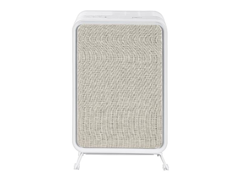 Purificateur d'air blanc avec un panneau avant en tissu beige clair, posé sur de petits pieds.