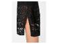 Détail d'une jupe en crochet noire avec fente latérale, montrant la jambe.