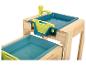 Une table de jeu en bois avec deux bacs bleus, un robinet et un évier jaune.