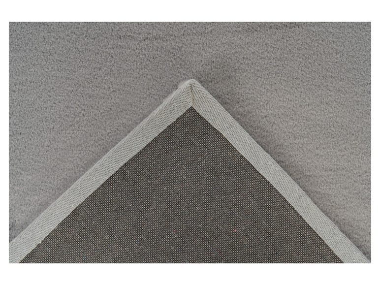 Détail d'un tapis gris avec une bordure grise.