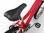 Vélo enfant rouge avec selle noire et pédales, vue détaillée.