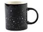 Une tasse noire avec des constellations, y compris les Gémeaux.