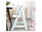Chaise haute en bois Stokke Tripp Trapp couleur menthe à l'eau dans une chambre d'enfant.