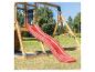 Toboggan rouge et balançoire en bois avec tableau noir disant « HAPPY » dans un jardin.