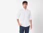 Chemise blanche et pantalon foncé pour homme.