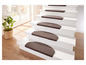 Tapis d'escalier marrons sur un escalier blanc.
