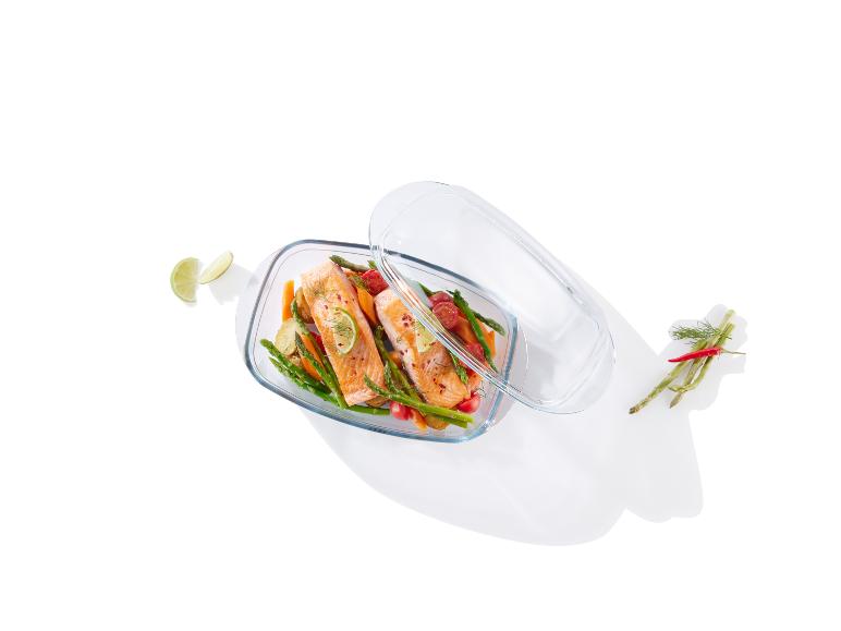 Saumon grillé avec des asperges et des tomates cerises dans un plat en verre.