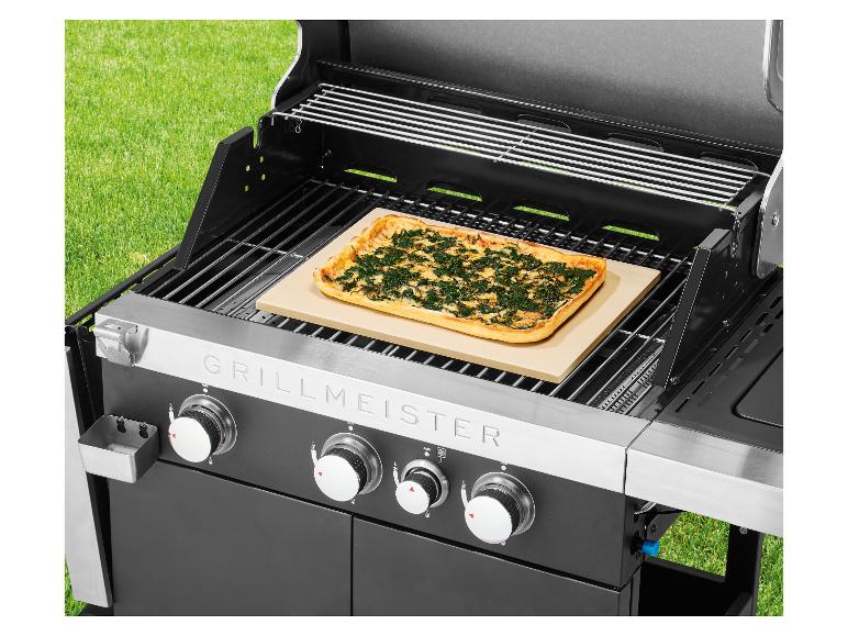 Barbecue avec pizza sur pierre de cuisson, à l'extérieur sur l'herbe