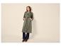 Femme en trench-coat vert, jean et mocassins marrons.