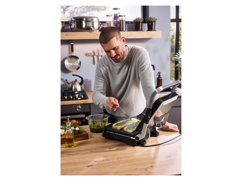 Un homme prépare à manger sur le gril viande-panini SILVERCREST® SKG 2000 F1.