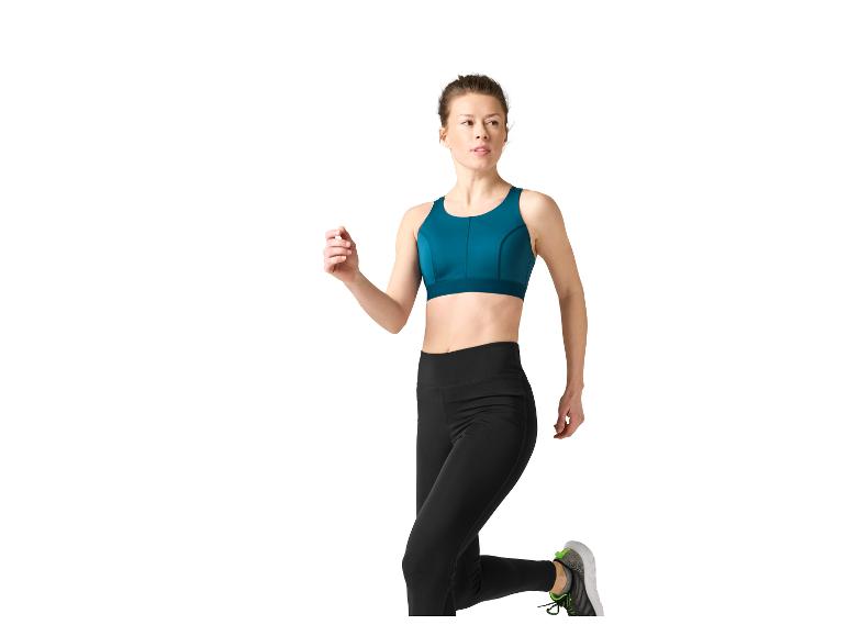 Femme en leggings noirs et brassière de sport sarcelle, courant.