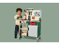 Enfant souriant jouant avec une perceuse jouet et un établi en bois.