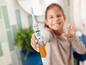 Un enfant tient une brosse à dents électrique Philips Sonicare.