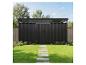 Abri de jardin noir moderne avec un chemin de dalles sur une pelouse verte.