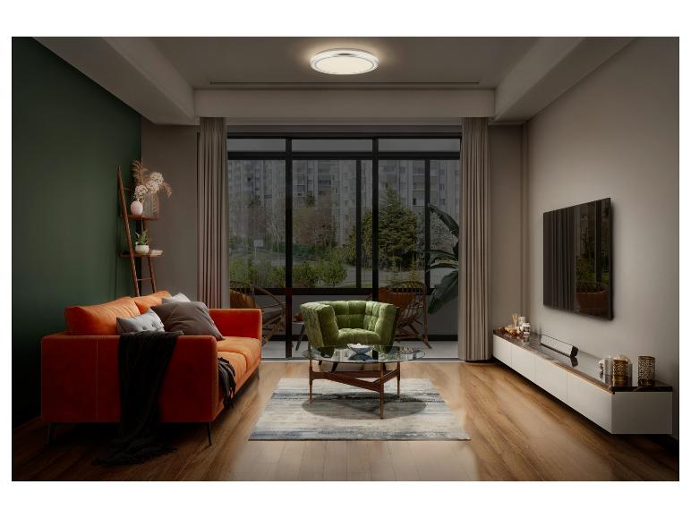 Salon avec canapé orange, fauteuil vert et table basse ronde.